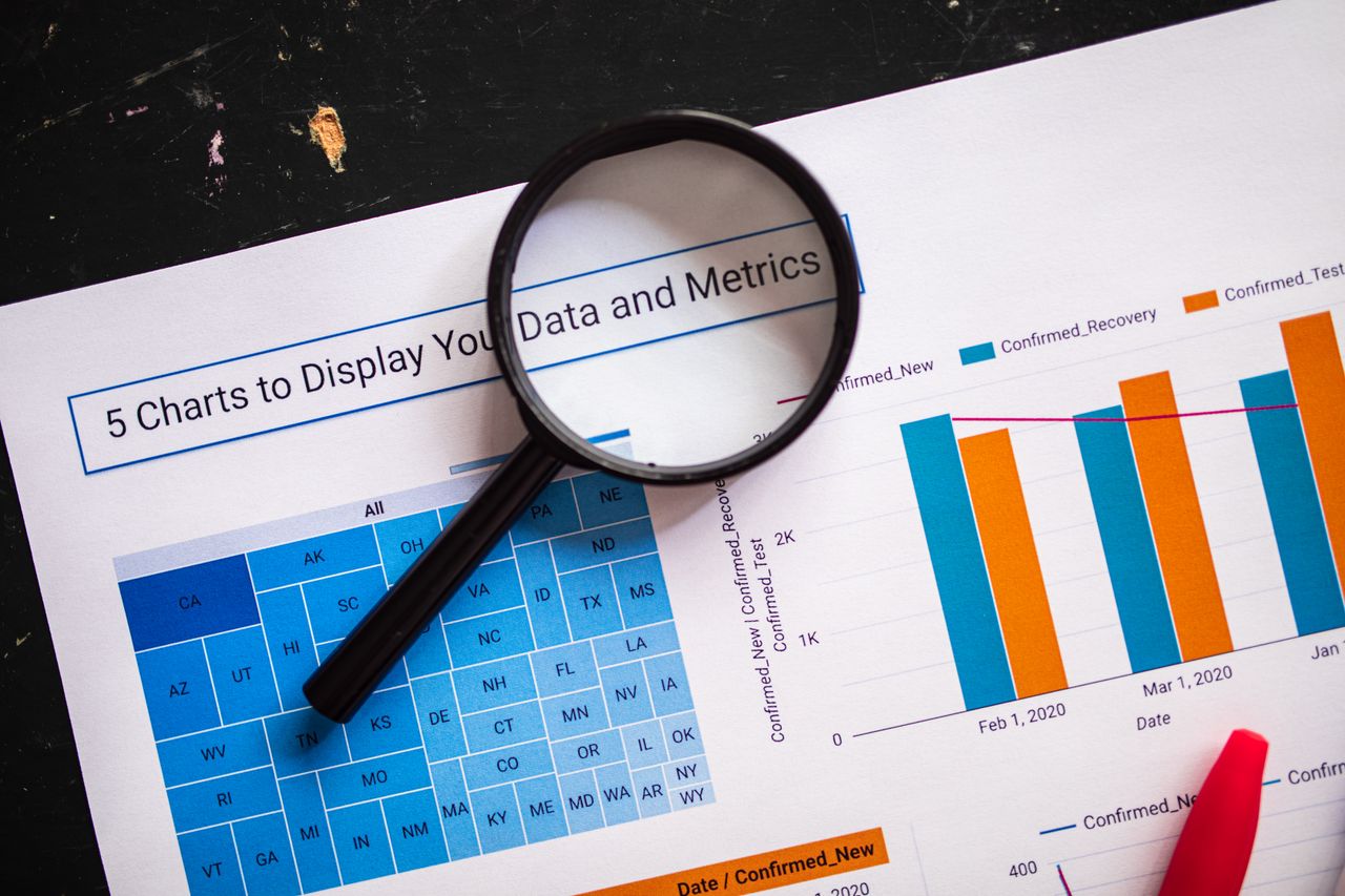 Crafting Captivating Headlines: Your awesome post title goes here Close-up of business charts with magnifying glass highlighting data insights.